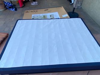 Queen-size box spring and metal bed frame.