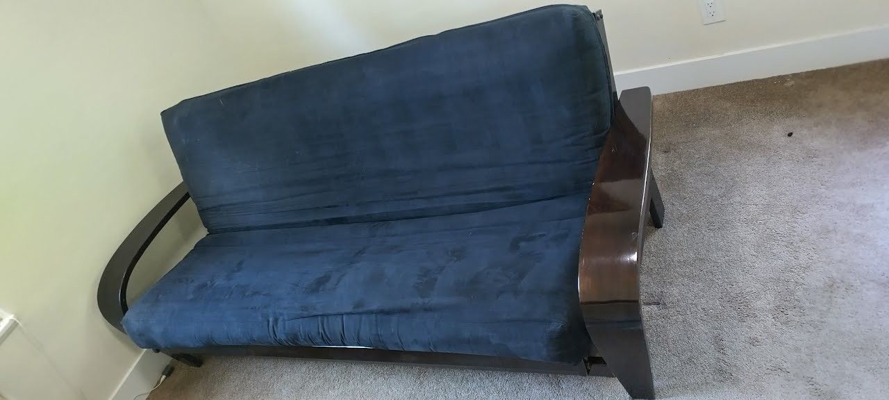 Futon, solid brown wood frame, black cloth cover. Heavy duty, good quality.