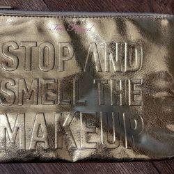 This is a limited edition gold Too Faced "Stop And Smell The MakeUp" cosmetic bag
