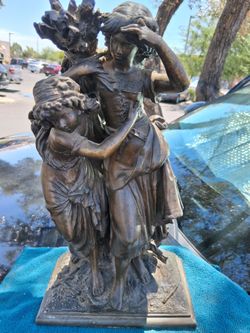 This bronze figurine is titled "Consolation" and was created by French artist Hippolyte François Moreau.