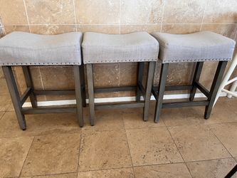 Three saddle style fabric barstools