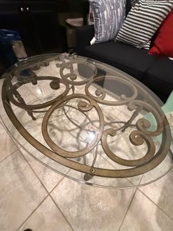 Elegant Oval Glass Coffee Table with Decorative Metal Base