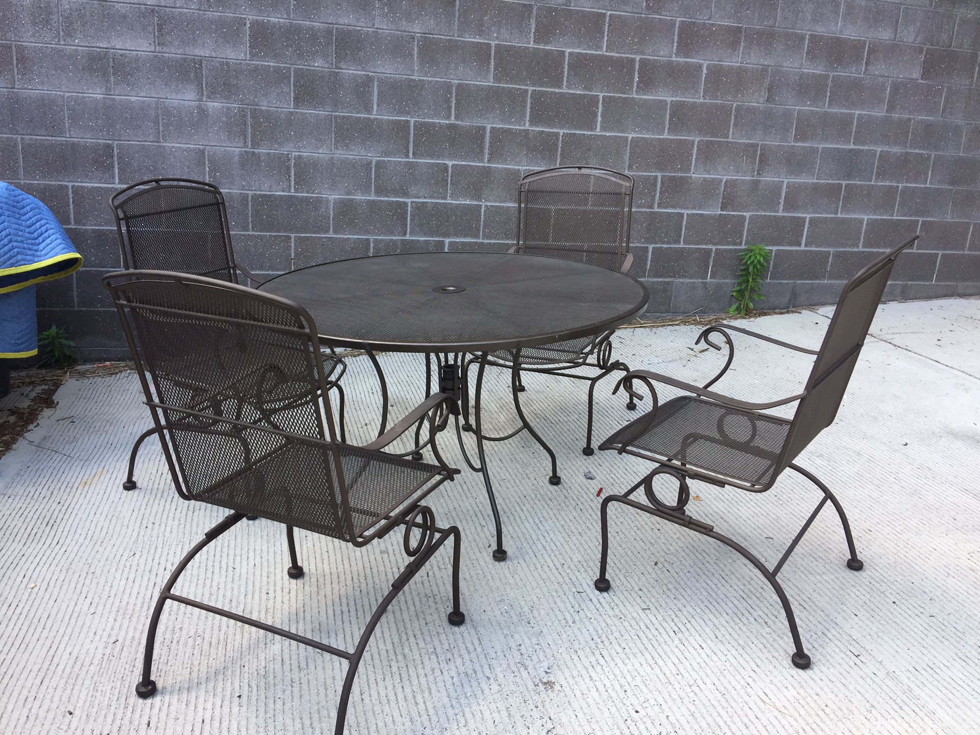 Brown. Patio set for sale. Metal table. With 4 rocket chairs like new we bought this last summer