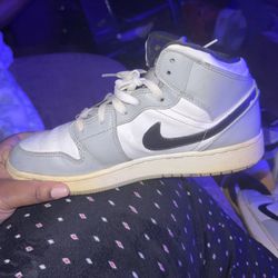 Nike Air Jordan 1 Mid sneakers in a light smoke grey and white colorway. 