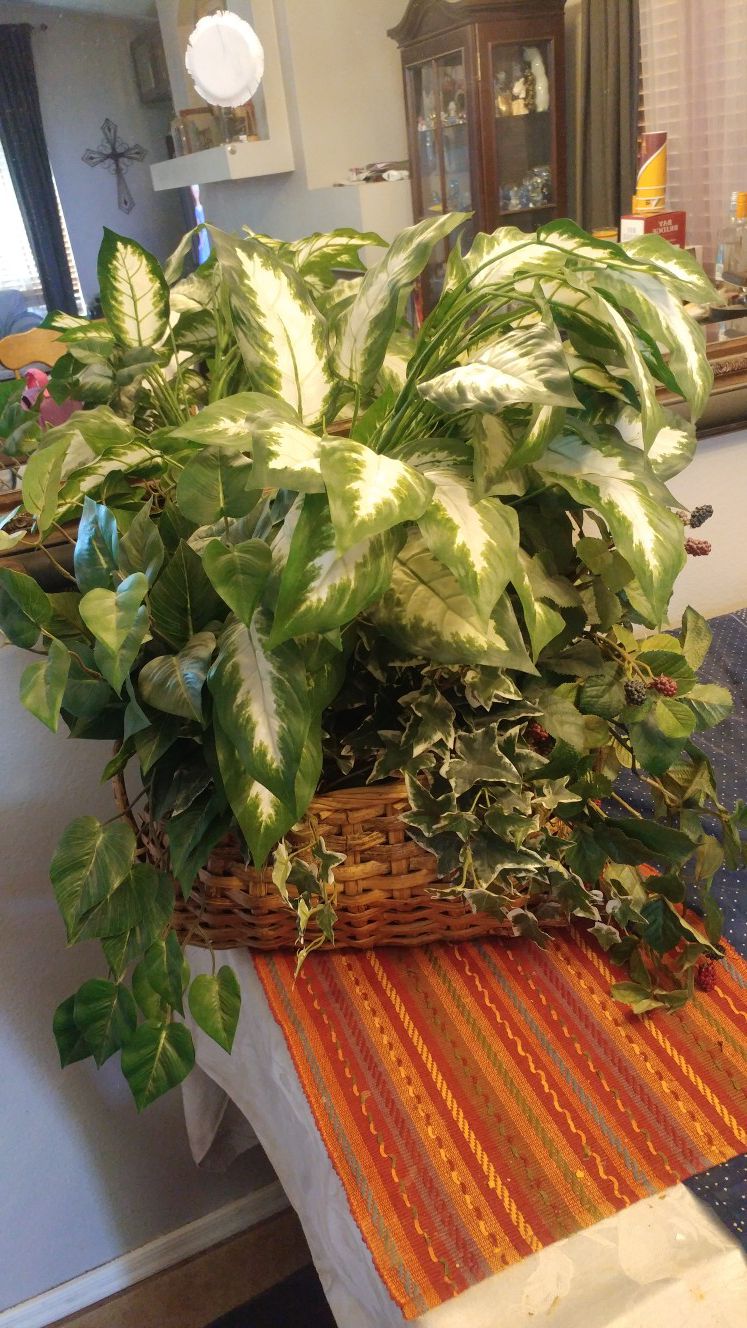 Large wicker basket filled with faux plant decor