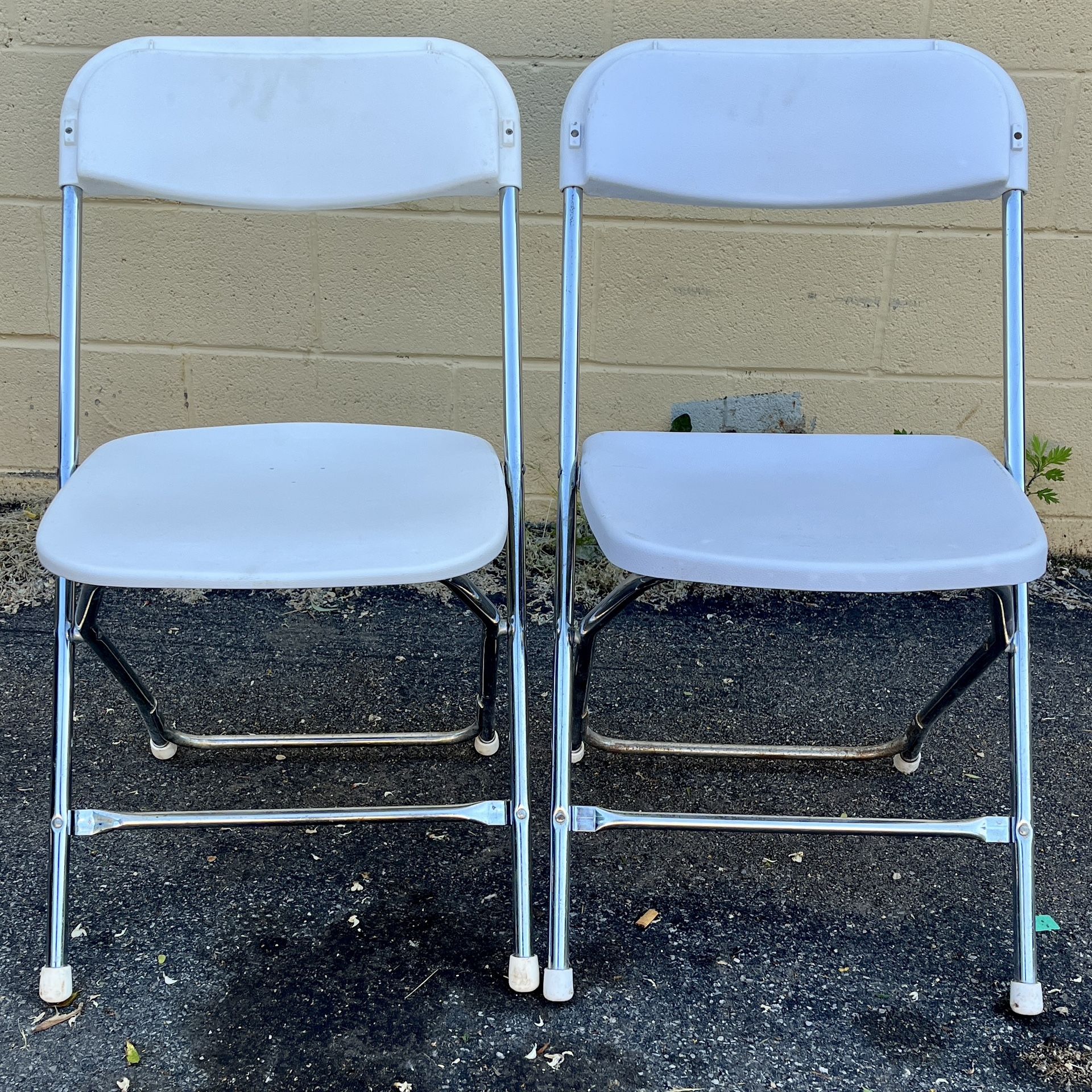 (2) White plastic folding chairs with metal frame. $10 each. Free to ask, I reply