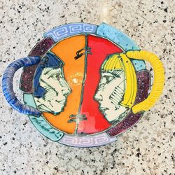 Artistic decorative plate with modern Picasso-style design. Vibrant colors, abstract faces, and decorative side handles.