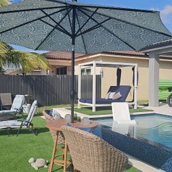 Bistro table with  chairs and umbrella.