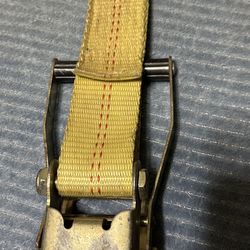 This is a ratchet tie-down strap with J-hooks, used for securing cargo on trailers or trucks.
