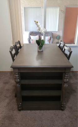 Dining room table with four chairs, built in shelving, and outlet