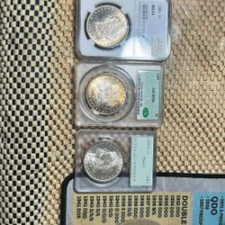 We Have Here A 1885MS 65 Morgan Silver Dollar And A 1889 Pack MS 64 Green Tag Green Beanie And A 1880 40MS 62. It’s A Rattler Old Holder. The 1885 MS 
