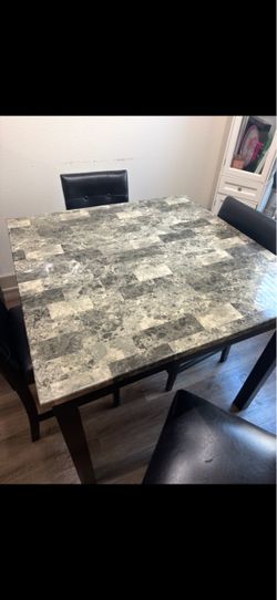 counter-height dining set with 1 table and 4 matching black chairs.