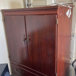 A Dresser With Mirror And A Matching Armoire It Holds A Tv