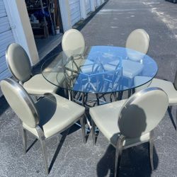 Chrome base glass  top table with six grey leather chairs… in excellent condition- like new. 