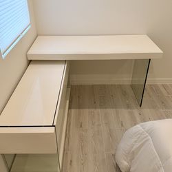 Escritorio blanco moderno en L con consola lateral y bases en vidrio y dos gavetas