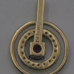 14kt yellow gold pendant w 27 diamonds 0.15pts  and ruby 0.25pts  2.7 grams . circle spins. 875202-1.