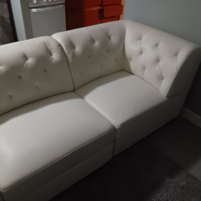 White Leather Sectional Couch With Attachable Metal Rods On The Bottom To Hold Them In Place