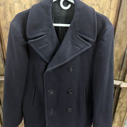 This jacket is a classic U.S. Navy-style pea coat, characterized by its heavy wool construction, double-breasted front, and broad lapels. These coats 