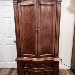 Beautiful high quality wood armoire in excellent condition. This is a heavy well built piece with a rich cherry mahogany finish and classic curved fro