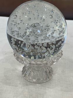 Vintage art glass orb with controlled air bubbles on a glass base.