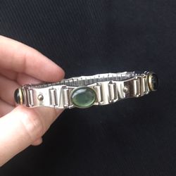 Silver color shiny elastic bracelet with green inserts