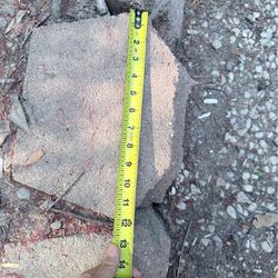 interlocking concrete retaining-wall blocks (Keystone-style), roughly 12–14 inches wide, with a rear lip t