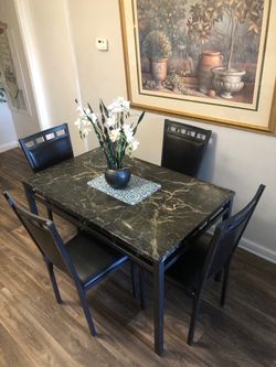 Black faux marble dining table set with 4 leather chairs