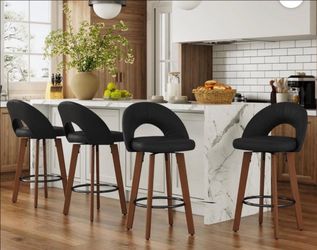 Set of four mid-century modern, faux leather-upholstered, counter-height swivel bar stools featuring curved wooden legs and metal footrests—ideal for