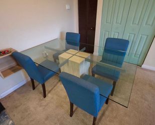 Glass top dining table with marble and metal base