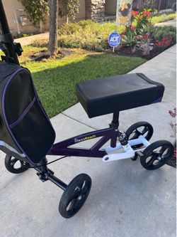 Knee Scooter- purple color, storage bag. Compatible right and left side injury. Rated 300 lbs