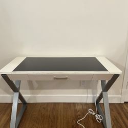 Desk with dark glass top, outlets, and USB ports