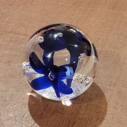 Vintage art studio glass paperweight features cobalt blue flowers 
suspended in clear glass with controlled bubbles.  2.75" tall. Has AY 
inscription 