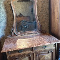 This is a Louis XV-style mirror with an ornate carved wood frame. 