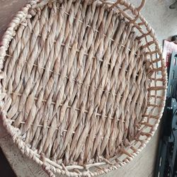 Beige Steel Frame Round Woven Food Tray Or Wall Decor features strands of grass woven into a spiral pattern on the front and On Steel rim. 