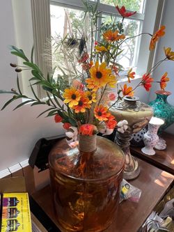 Beautiful jarrón de cristal ámbar con flores incluidas a tono con colores entre naranjas y amarillas