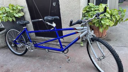 Two-rider bicycle with a blue and silver frame. 26 inch alloy tires . Sturdy steel frame designed for two riders on