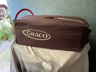 Brown Graco baby playpen