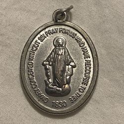 Silver Toned Miraculous Medal, a devotional item associated with the Virgin Mary