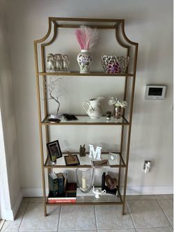Gold metal bookshelf with glass shelves