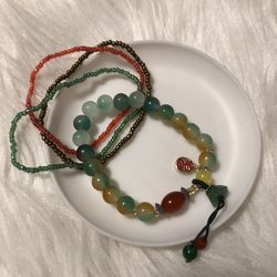 FOUR bundled bead bracelets red/jade-color