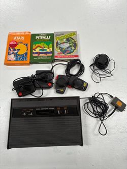 Atari console with three games, two joy sticks, two paddles and cords (untested)