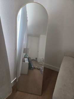 Gold standing body mirror.