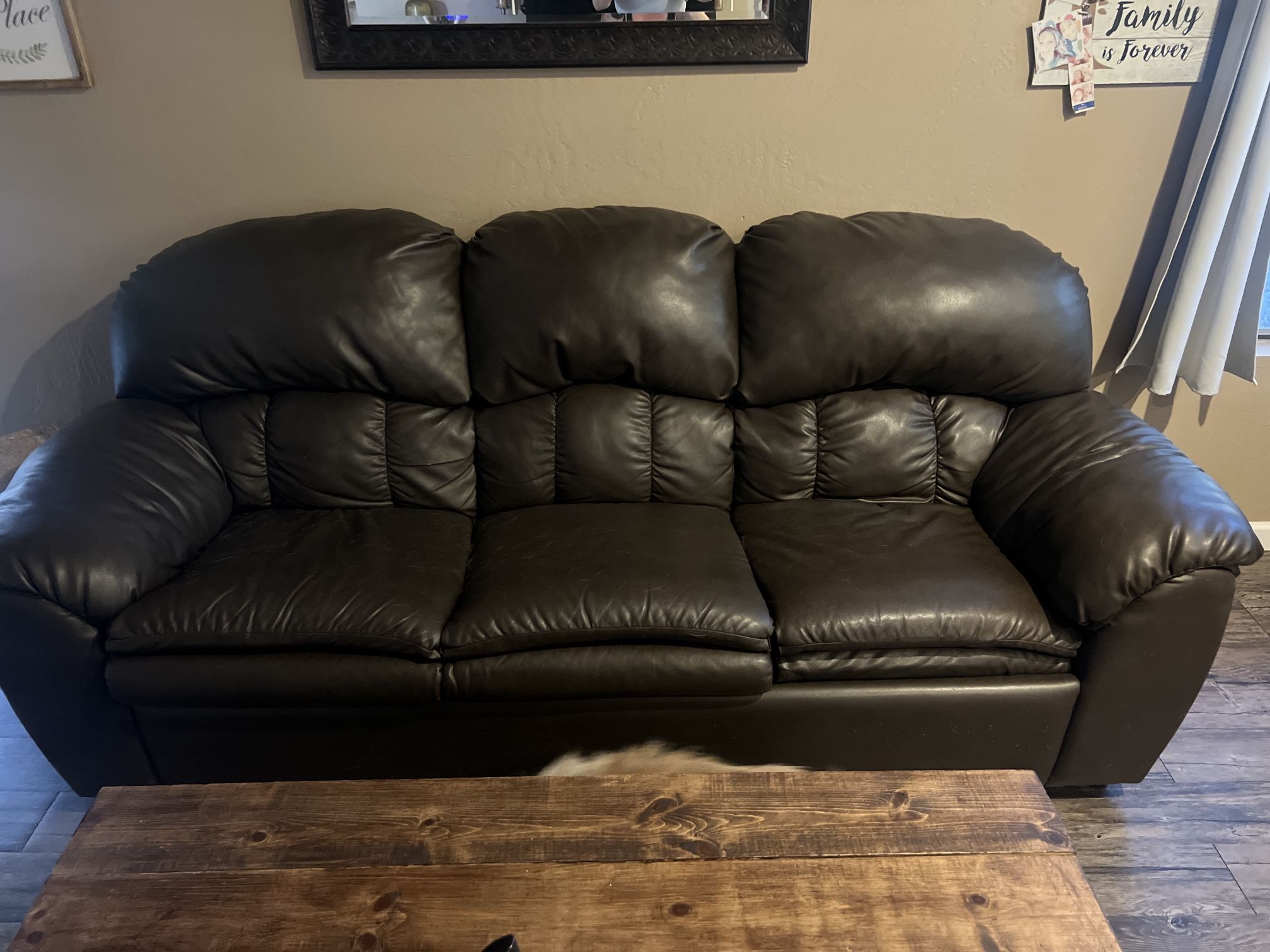 Brown faux leather couch with pullout bed.