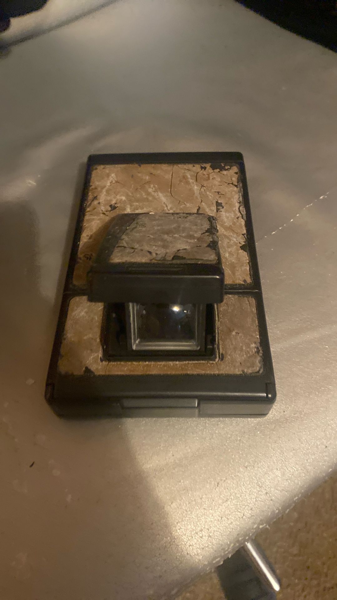 The image shows a vintage Polaroid SX-70 camera. This camera is a single-lens reflex (SLR) instant film camera known for its folding design.