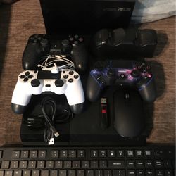 PS4, 2 Elite Controllers, Regular Controller Dragon Grip, Dobe Charging Station, ASUS Gaming Router, Wireless Mouse And Keyboard, USB Drive, Headphone