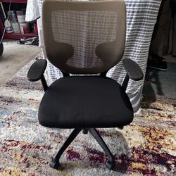 Comfortable office chair has breathable tan mesh back and padded black fabric seat. It includes adjustable height lever and rolling swivel base with f