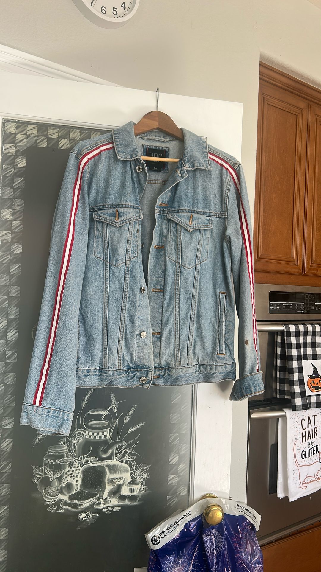 Denim jacket with white and red stripes down the side of the sleeve