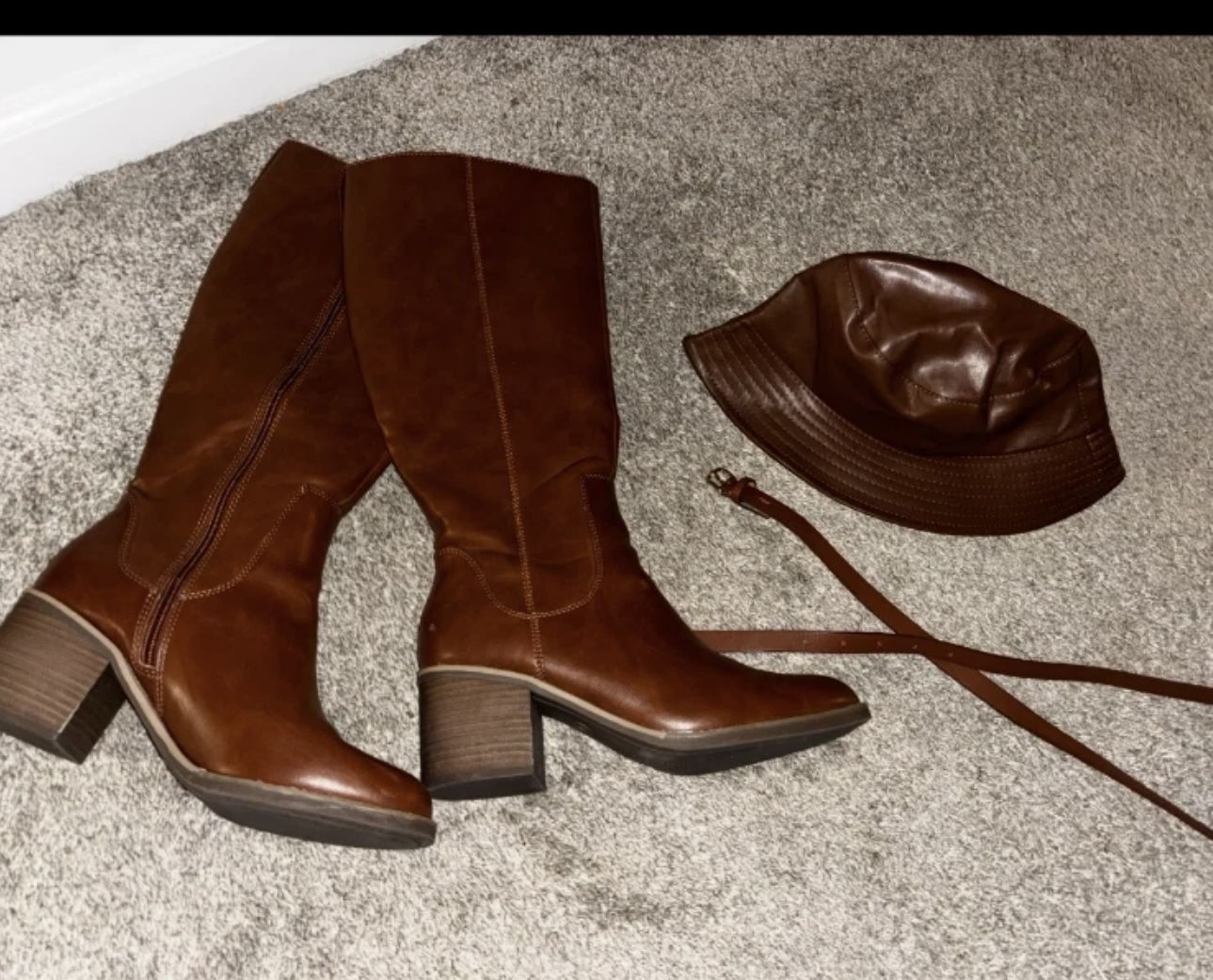 Brown knee-high boots + a matching hat and belt for a stylish look.