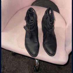 black leather ankle boots with buckle and zipper details.