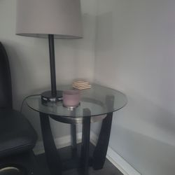 Glass Top Round five table setThis round side table features a clear glass top with a metal accent ring. It has a dark wood base with an interesting g